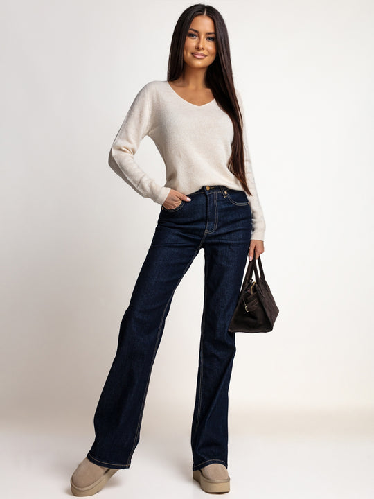 Jasnobeżowy sweter OH HONEY PURE ze 100% wełny merino w stylizacji z granatowymi jeansami – cała sylwetka z przodu.