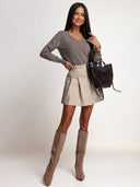 Sweter OH HONEY PURE taupe wpuszczony w spódniczkę z wysokim stanem – stylizacja z kozakami i brązową torebką.